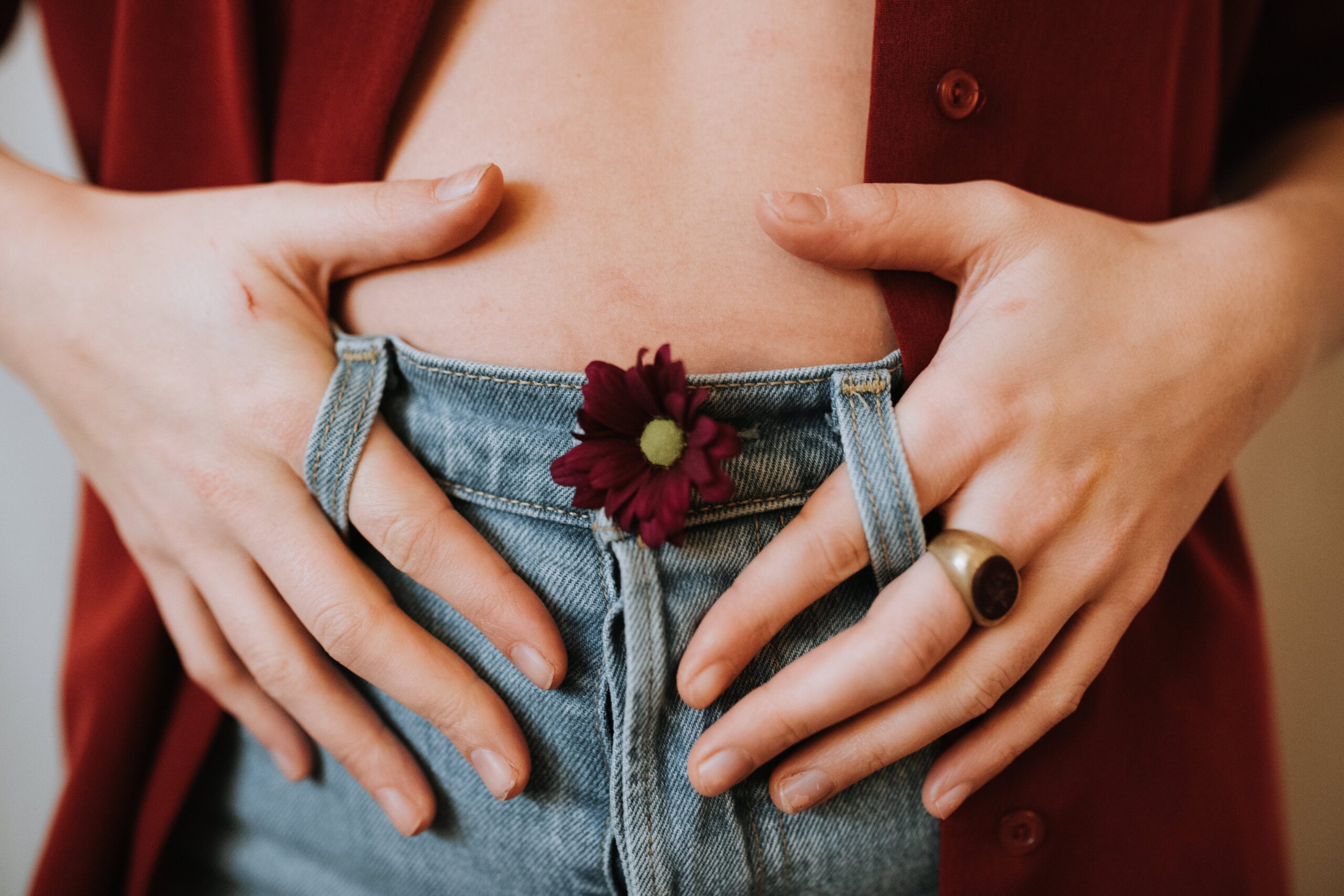 Hands holding stomach over jeans. Gut Health and Rosacea Image